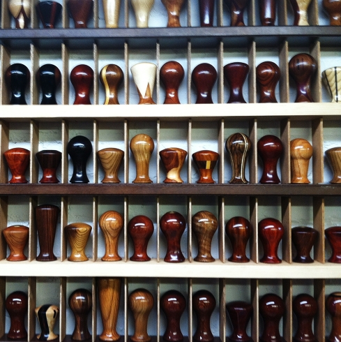 A case full of dozens of beautiful, highly polished, custom tamper handles